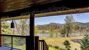 Une terrasse en bois offrant une vue sur un lac et des montagnes.