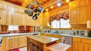 Une cuisine spacieuse avec des meubles en bois, un îlot central et un tapis rouge.