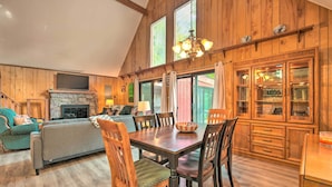 A cozy living room with a fireplace, wooden dining table, and matching chairs. - Mtn Getaway w/ Indoor Hot Tub, Golfers Welcome! (White Haven)
