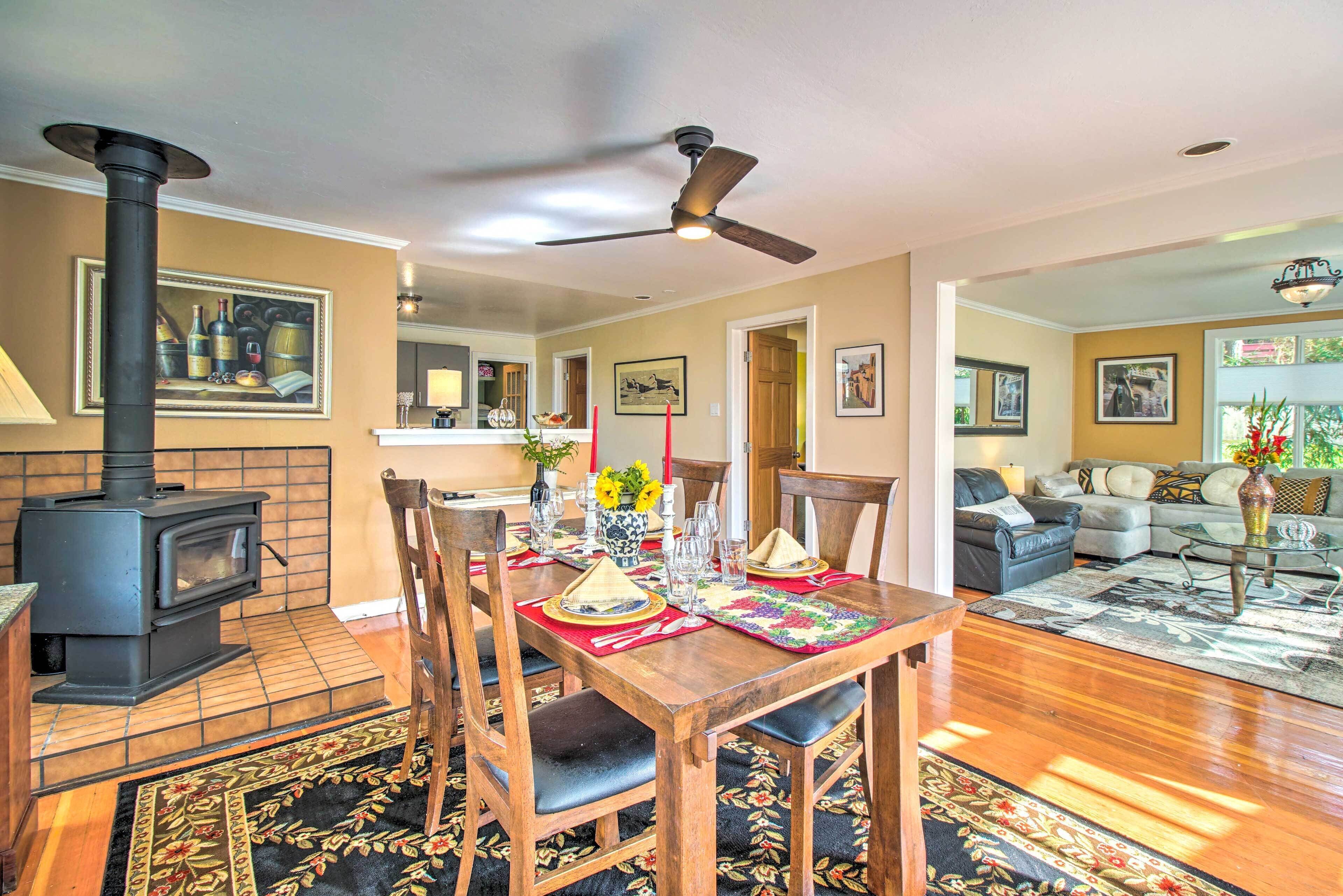 Un comedor con una mesa de madera, sillas y una chimenea en el centro.