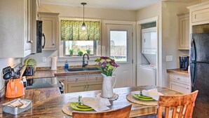 A kitchen with wooden cabinets, a dining table with chairs, a sink, and a refrigerator. - Near Wineries & Hiking: Lawndale Home w/ Fire Pit! (Lawndale)