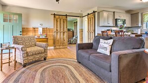 A spacious living room with a grey sofa, patterned armchair, and a large woven rug. - Near Wineries & Hiking: Lawndale Home w/ Fire Pit! (Lawndale)