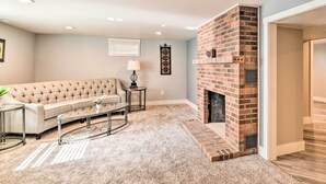 A living room with a beige sofa, a glass coffee table, a fireplace, and a carpeted floor. - Renovated Apartment ~ 7 Mi to Dtwn Billings (Billings)