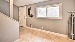 A hallway with a white door, a large window, and a wall-mounted arrow decoration. - Renovated Apartment ~ 7 Mi to Dtwn Billings (Billings)