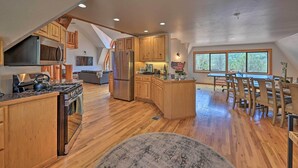 A spacious kitchen with wooden cabinets, a large island, and a dining area with a table and chairs. - Hot Tub & Mtn View: Dog-friendly Payson Getaway! (Payson)