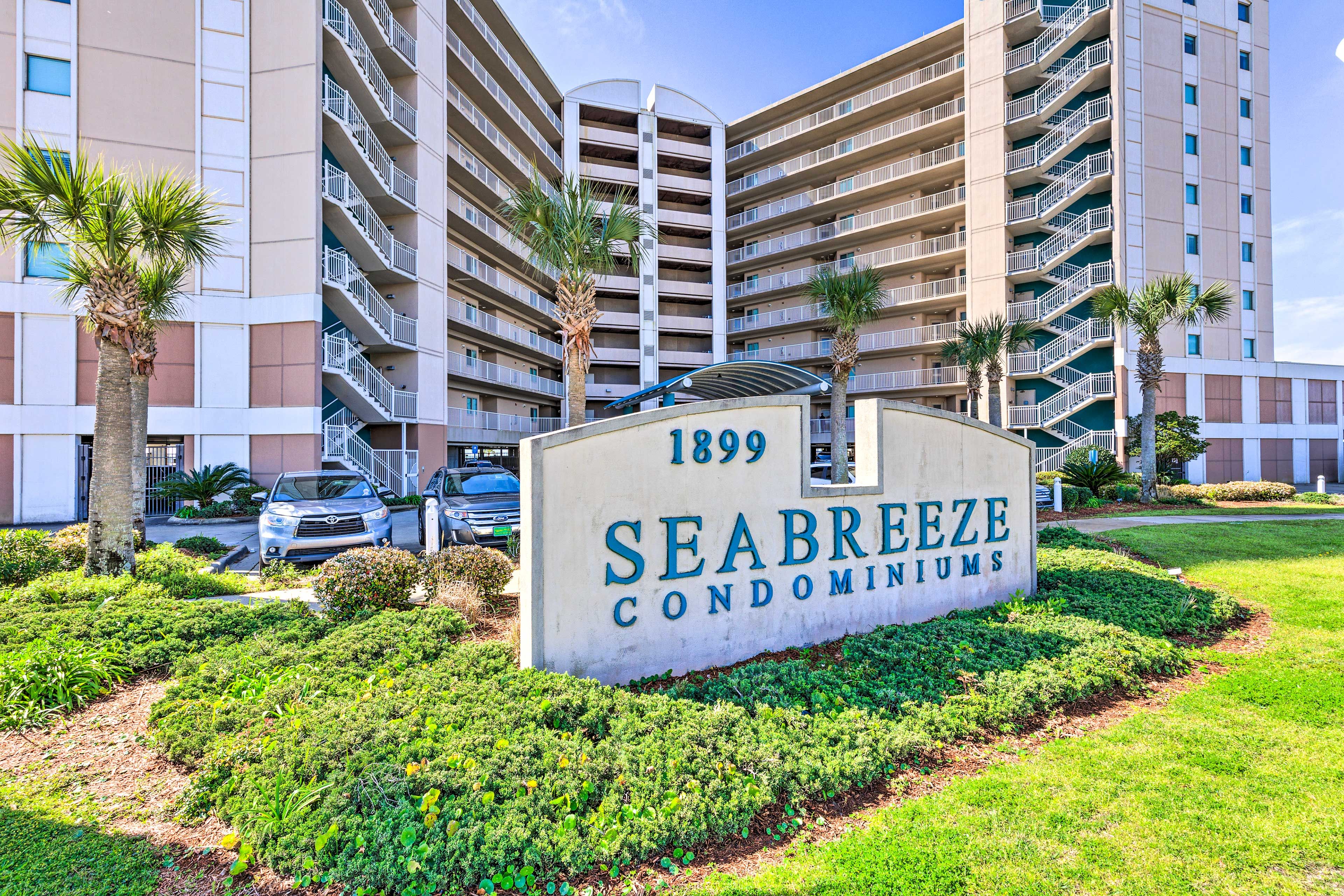 Señal de Seabreeze Condominiums con un edificio moderno al fondo.