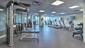 A gym with various exercise equipment, including treadmills, weight machines, and dumbbells. - Spacious Biloxi Getaway w/ Pools & Beach Access! (Biloxi)