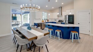 Een moderne keuken met een centraal eiland, witte kastjes en een blauwe accentmuur.