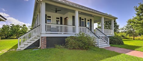 A two-story house with a covered porch, a brick foundation, and a chimney.