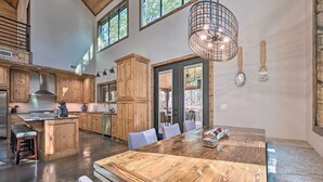 Una cocina amplia con armarios de madera, una isla grande y un comedor con una mesa larga.