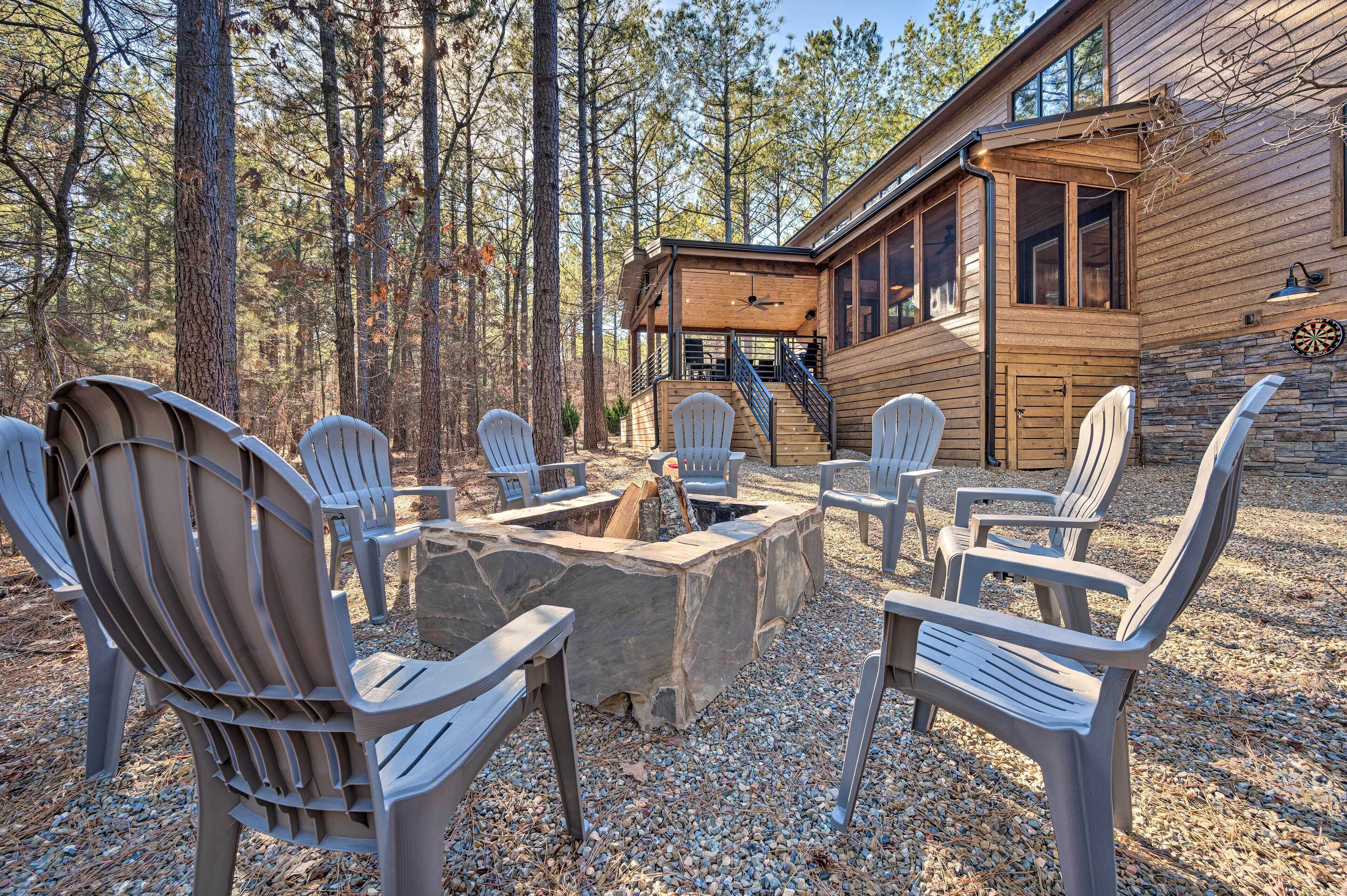 Una cabaña de madera con un hogar de piedra rodeado de sillas Adirondack.