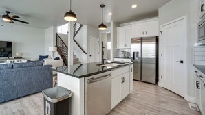 A modern kitchen with white cabinets, stainless steel appliances, and a central island.