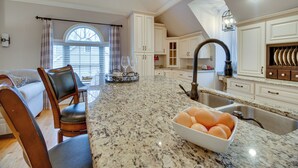 A kitchen with granite countertops, a bowl of eggs, and a dining area with a sofa and chairs. - Cozy Virginia Vacation Rental w/ Seasonal Pool! (Nokesville)
