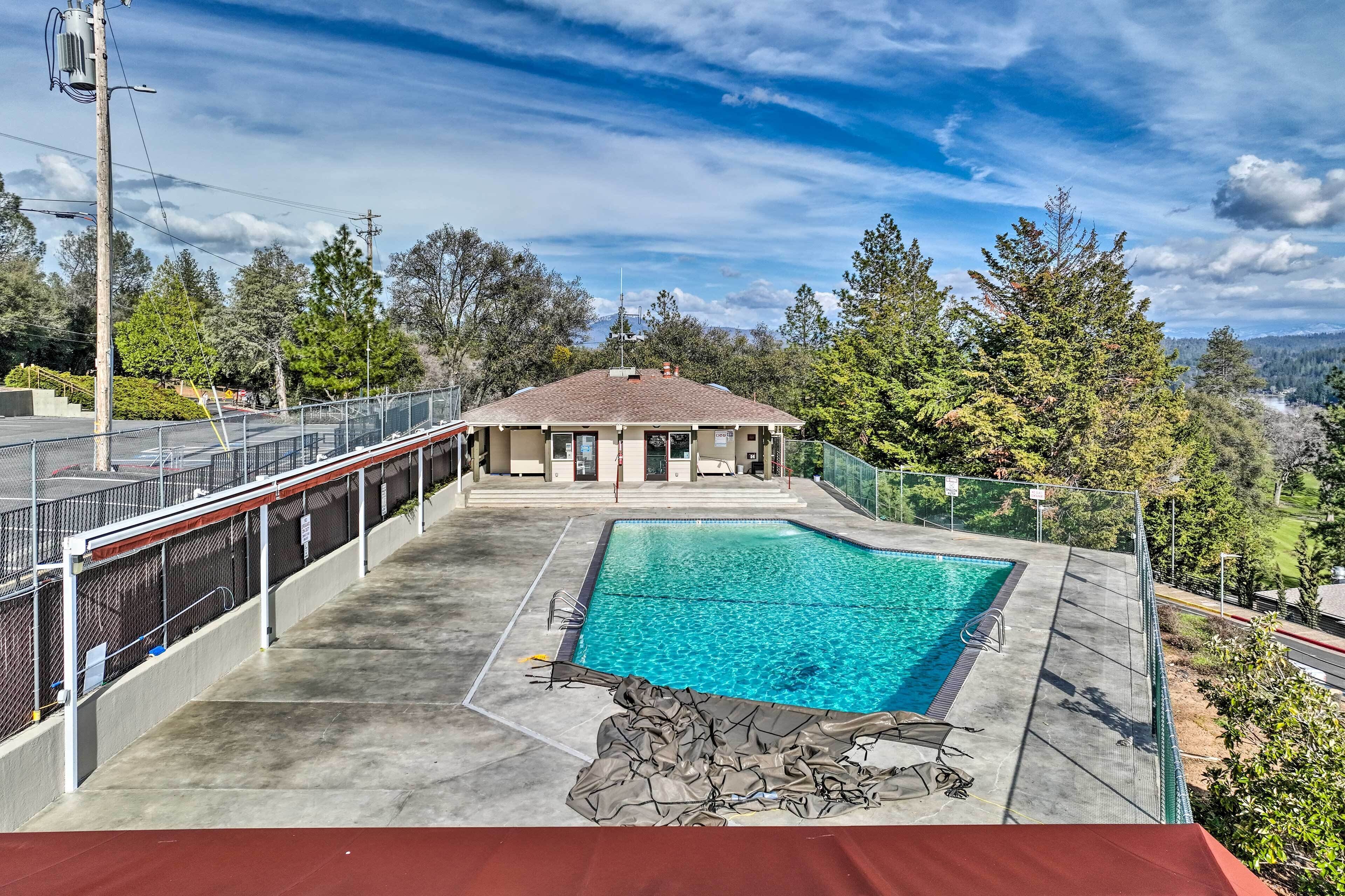 Une piscine avec vue sur une maison et des arbres en arrière-plan.
