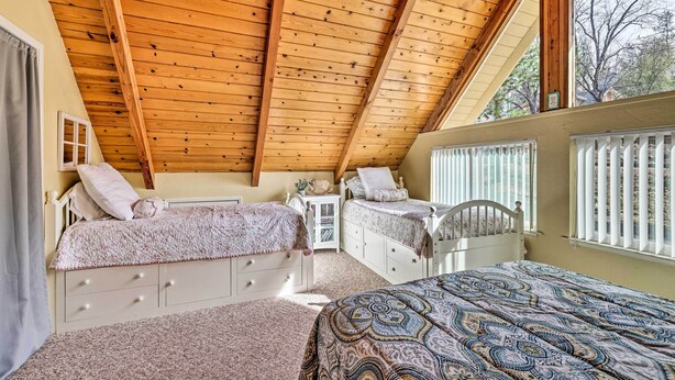 A bedroom with two beds, wooden ceiling beams, and a window with blinds. - California Cabin w/ Lake Access: 28 Mi to Yosemite (Groveland)