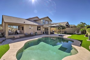 A house with a swimming pool, patio furniture, and a covered seating area. - Complimentary Heated Pool: Goodyear Getaway! (Goodyear)