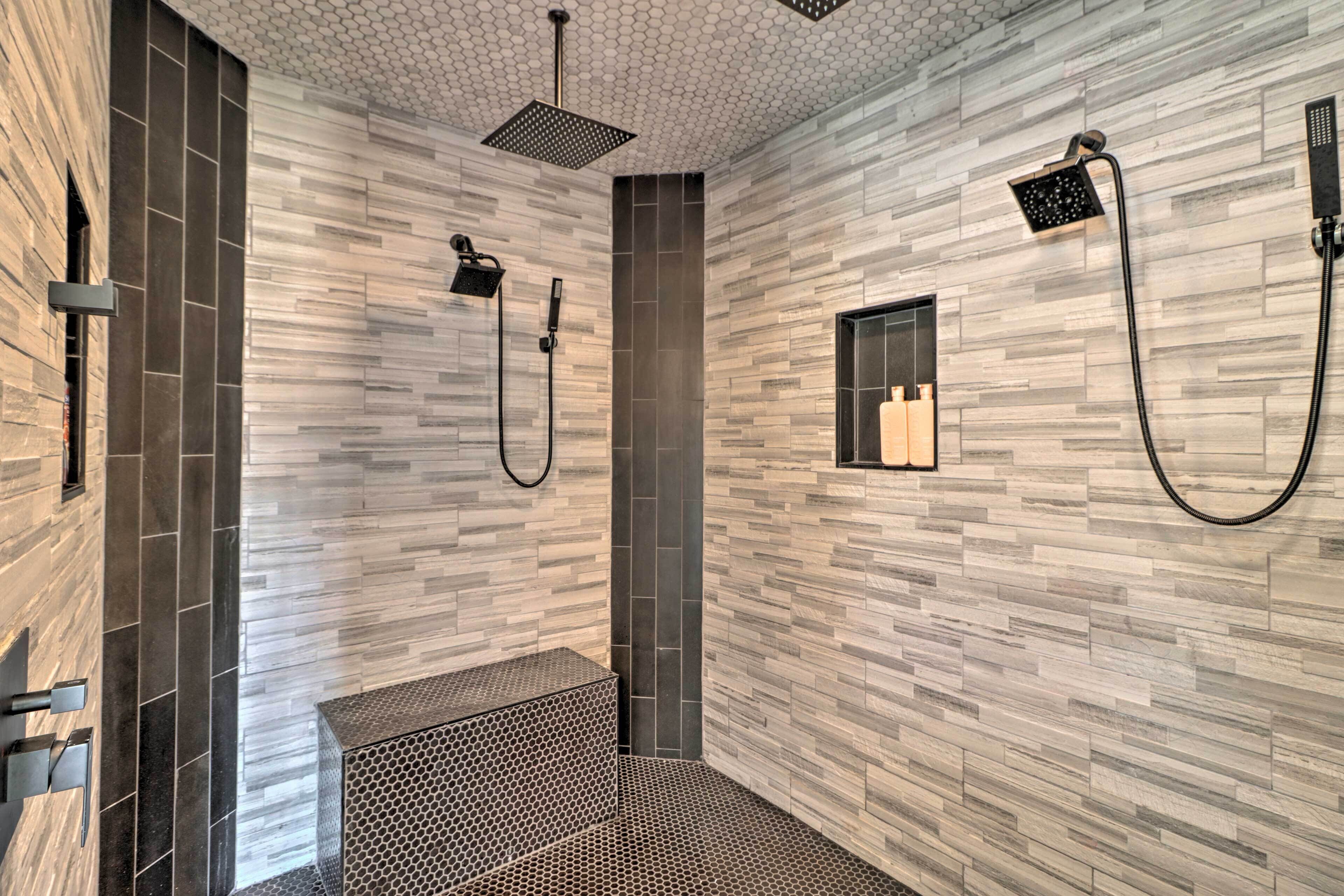 Een moderne badkamer met een geometrisch tegelontwerp, een inloopdouche en een klein raam.