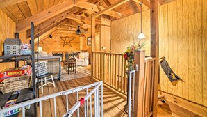 A cozy wooden cabin interior with a loft bedroom, a dining area, and a living room. - Quiet Cabin Retreat on 30 Acres Near Kentucky Lake (New Concord)