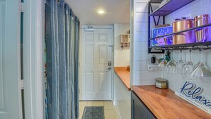 A kitchen with a wooden countertop, a shelf with copper pots, and a sign that says "Relax". - Walk to Shore! Top-floor Daytona Beach Condo (Daytona Beach Shores)