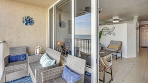 A balcony with wicker furniture, a ceiling fan, and a view of the ocean. - Walk to Shore! Top-floor Daytona Beach Condo (Daytona Beach Shores)