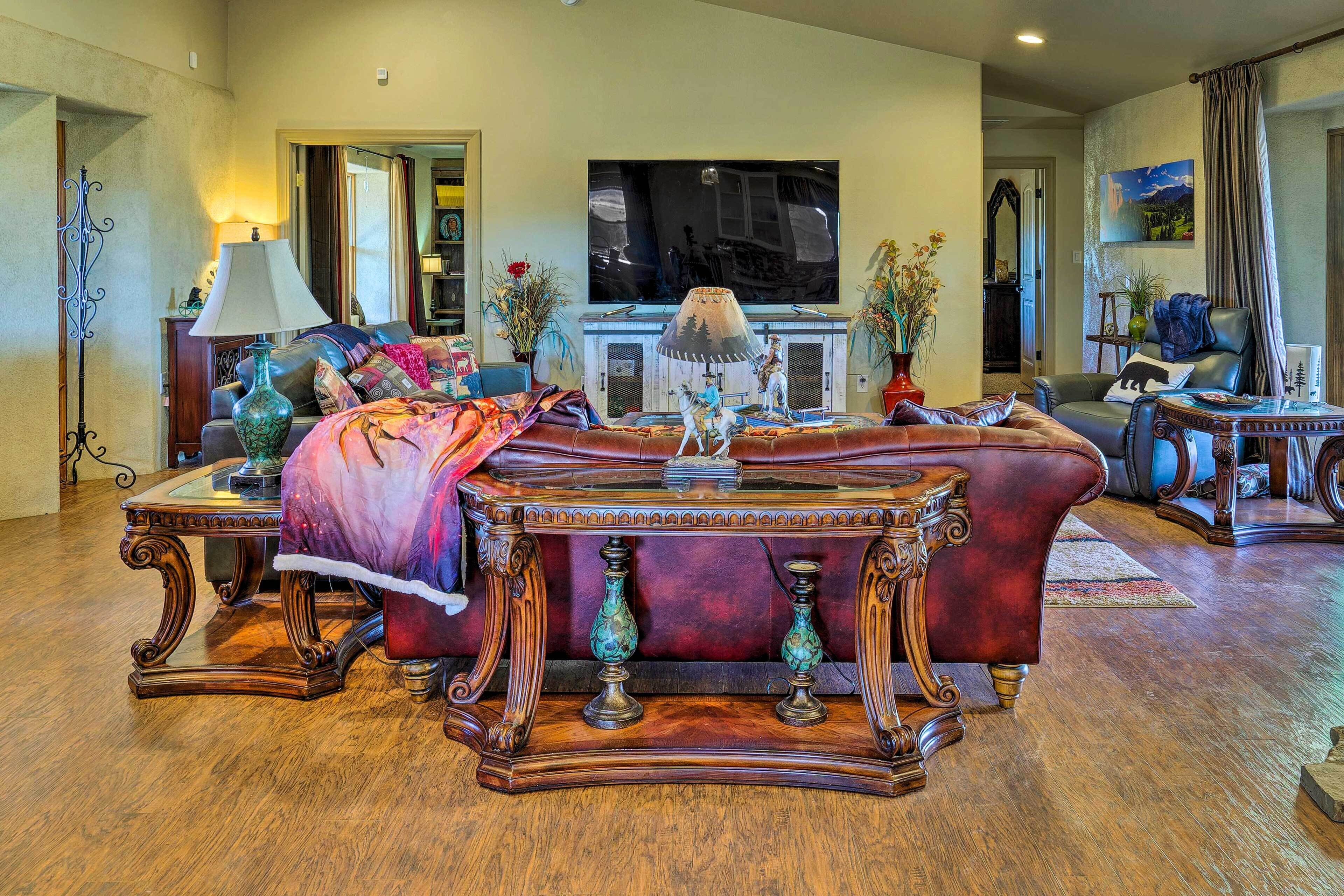 A spacious living room with a large TV, comfortable seating, and a fireplace.