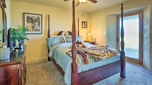 A bedroom with a four-poster bed, a ceiling fan, a large window with a view, and a dresser with a plant. - Beulah Home w/ Wraparound Porch & Mtn Views (Beulah)