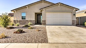 A single-story house with a garage, a front door, and a small front yard with gravel and plants. - Quiet Family Home w/ Yard ~ 3 Mi to Luke Afb! (Glendale)