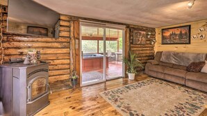 A log cabin interior with a fireplace, a sofa, a rug, and a painting on the wall. - Supreme Family Getaway in the White Mountains! (Rumney)