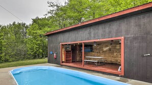 A modern building with a swimming pool, wooden deck, and a covered patio area. - Supreme Family Getaway in the White Mountains! (Rumney)