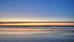 Una platja amb mar tranquil·la i cel serè.