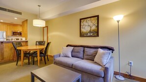 Ein Wohnzimmer mit einer Couch, einem Couchtisch und einem Essbereich mit Stühlen und einem Tisch.