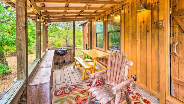 A wooden porch with a table and benches, a grill, and large windows. - Mountian View Retreat < 2 Mi to White River! (Mountain View)