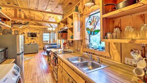 A wooden cabin interior with a kitchen, dining area, and a cozy living space. - Mountian View Retreat < 2 Mi to White River! (Mountain View)