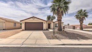 A residential house with a garage, palm trees, and a clear sky.