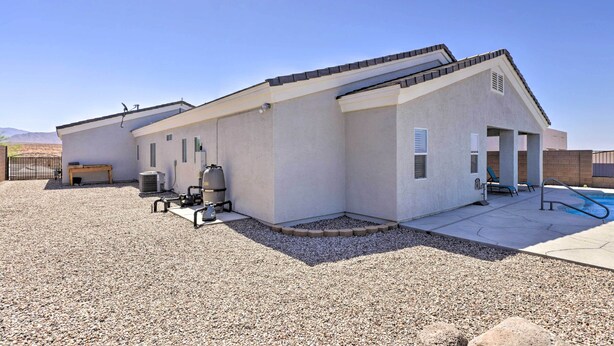A modern building with a pool, outdoor seating, and a barbecue grill.