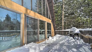 A modern building with large windows and a wooden deck surrounded by snow. - Cozy A-frame Cabin w/ Pool Table: 8 Mi to Mt Snow! (Wilmington)