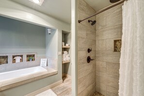 A bathroom with a bathtub, shower, and a shelf with towels. - Kalispell Main House < 15 Mi to Flathead Lake (Kalispell)