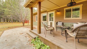 A covered porch with wicker furniture and a fan, surrounded by trees. - Kalispell Main House < 15 Mi to Flathead Lake (Kalispell)