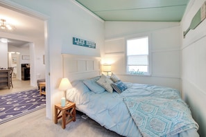 A bedroom with a bed, a nightstand, a lamp, a window, and a sign that reads "LAKE HOUSE". - Walk to Lake: Nautical Akron Cottage w/ Deck! (Akron)