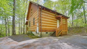 Eine Blockhütte mit Holzfassade, einer Veranda und einer Treppe zum Eingang.