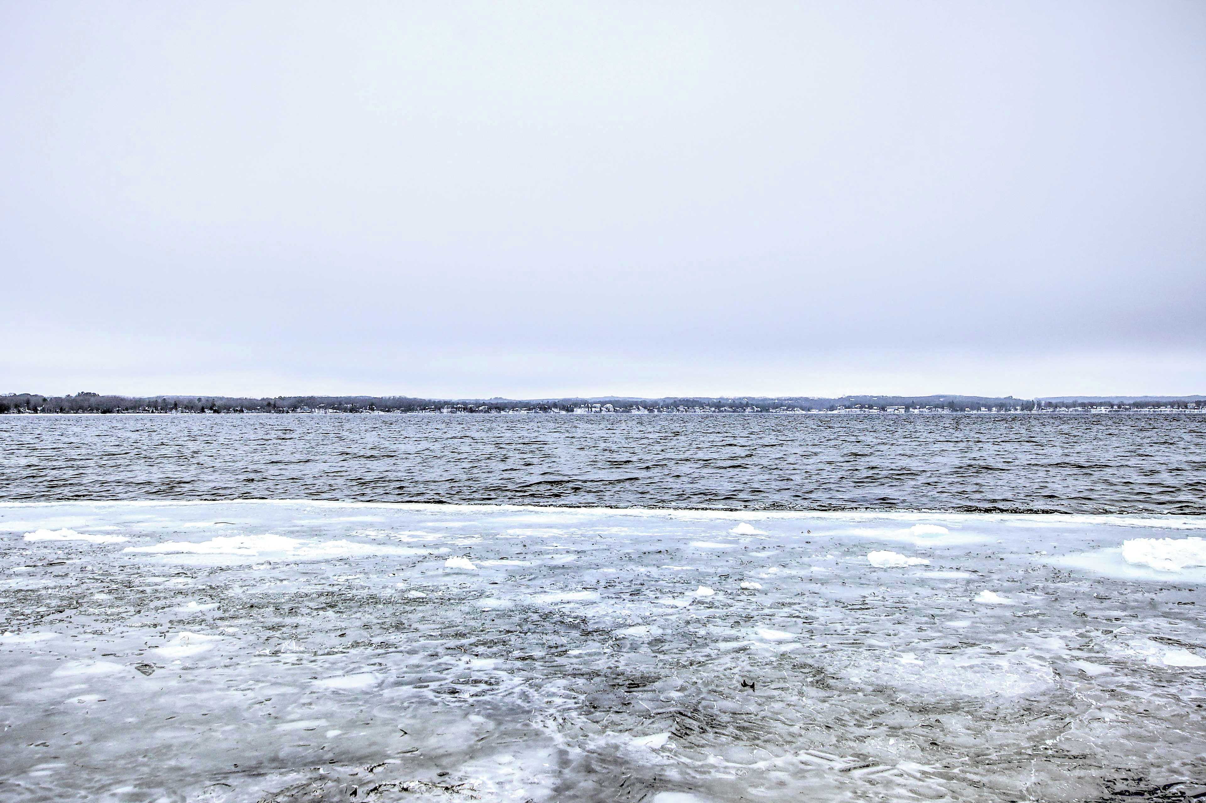A frozen lake with a distant shoreline.