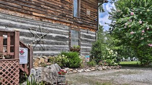 A rustic wooden cabin with a star decoration, a welcome sign, and a garden with rocks, plants, and a bench. - Fire Pit & Deck! Cozy Smoky Mtn Retreat on River (Townsend)