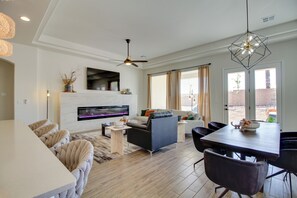 A modern living room with a fireplace, a dining area, and a seating arrangement.