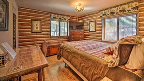 A log cabin-style bedroom with a wooden bed, a dresser, a desk, and framed pictures on the walls. - Family & Dog Friendly: Rustic Lakeside Cabin (Lakeside)