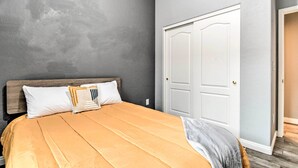 A bedroom with a bed, a wooden headboard, a white door, and a gray wall. - Private Pool & Community Perks: Mesa Home! (Mesa)