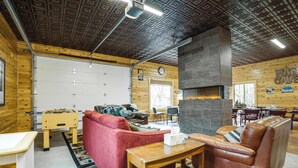 Ein gemütliches Interieur mit Holzbalkendecke, Kamin, rotem Sofa, Ledercouch und einem Kicker.