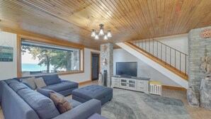 Een moderne woonkamer met een grote hoekbank, een flatscreen televisie en een stenen openhaard.