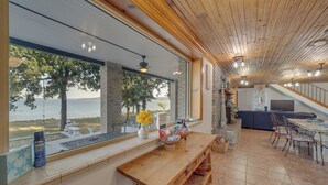 Een moderne keuken met een groot schiereiland, een eethoek met een houten bank en uitzicht op het meer.