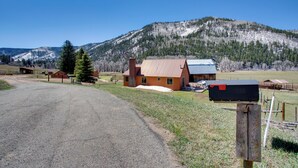 A rural house with a gravel driveway, a mailbox, and a mountain backdrop. - Cozy Dolores Getaway: Hike, Fish + More! (Dolores)