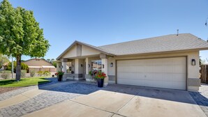 A residential house with a garage, a driveway, and a landscaped front yard. - Glendale Vacation Rental: Near State Farm Stadium (Glendale)